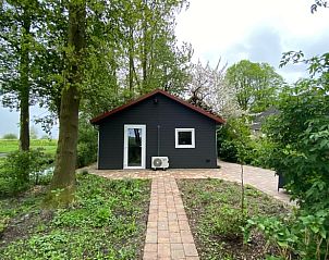 Vooraanzicht van Huisje in Nij Beets, vakantiewoning in Nij Beets, omgeven door bomen en natuur.
