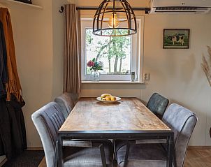 Eethoek in Huisje in Nij Beets, vakantiewoning in Friesland, met uitzicht op de groene omgeving.