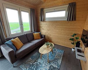 Gezellige woonkamer in Huisje in Swichum met uitzicht op het Friese platteland in Friesland.
