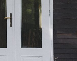 White door of Holiday Home in Nieuwehorne, overlooking the Frisian countryside.