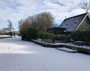 Winterlandschap bij Vakantiehuisje in Bartlehiem met besneeuwd kanaal op het Friese platteland.