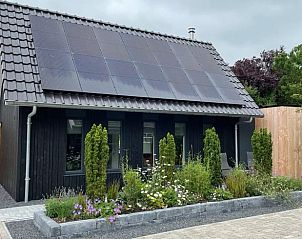 Duurzaam vakantiehuis met zonnepanelen in Bartlehiem, omgeven door tuin op het Friese platteland.