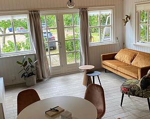 Lichte woonkamer in Huisje in Damwald, vakantiehuis in Damwld, Friesland, met stijlvolle inrichting en uitzicht op de tuin.