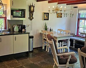 Landelijke keuken en eetruimte in Huisje in Jistrum met uitzicht op de tuin.