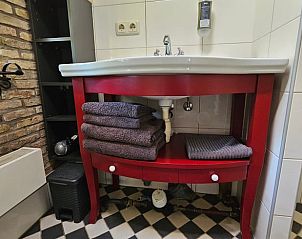 Opgeruimde badkamer in Jistrum vakantiehuis met handdoeken en moderne wastafel.