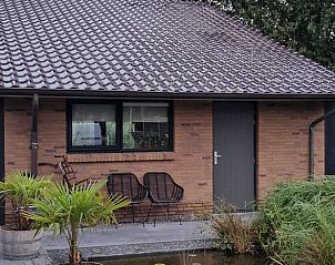 Charmante buitenkant van Huisje in Kollum, vakantiehuis in Friesland, met gezellige zithoek op het terras.