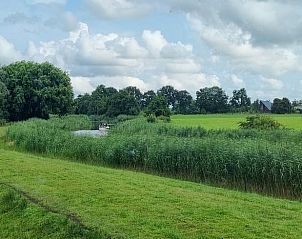 Rustgevende omgeving van Huisje in Kollum, Friesland, met weids uitzicht over het Friese platteland en water.