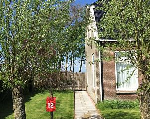 Pad naar Vakantiehuisje in Pingjum met landelijke charme en groene omgeving.