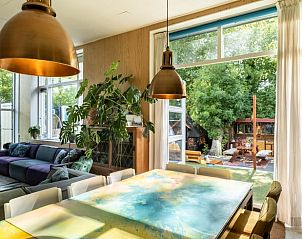 Eetruimte in Vakantiehuisje in Boksum, Friesland, met grote tafel en uitzicht op de groene tuin.