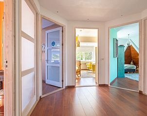 Hal in Vakantiehuisje in Boksum, Friesland, met houten vloer en toegang tot verschillende kamers.