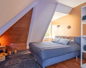 Slaapkamer met schuine wanden in Vakantiehuisje in Boksum, Friesland, met ruime bedden en natuurlijke lichtinval.