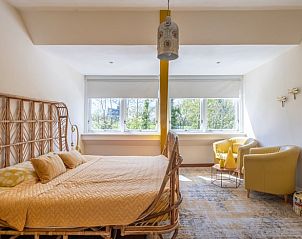 Lichte slaapkamer in Vakantiehuisje in Boksum, Friesland, met grote ramen en comfortabele stoelen.