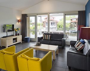 Gemtliches Wohnzimmer des Bungalows Zilvermeeuw Comfort 6 in Noardburgum, Friesland, mit Blick auf die friesische Landschaft.