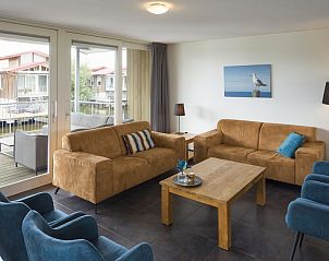 Gemtliches Wohnzimmer im Bungalow Goudplevier Wellness Plus 10, Noardburgum, Friesland, mit groer Sitzecke und Blick auf die friesische Landschaft.