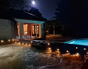 Verlichte jacuzzi bij nacht in Vakantiehuis in Fochteloo, Friesland, voor een luxe ontspanningservaring.