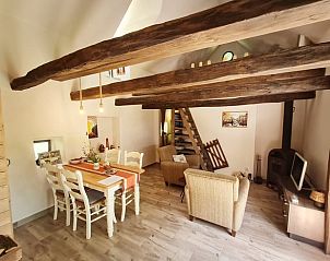 Gemtlicher Innenraum im Ferienhaus in Modry Kamen, Banska Bystrica, Slowakei mit Holzbalken und Essbereich.