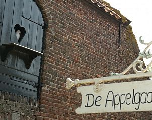 Rustieke bakstenen gevel van De Appelgaard, een bed and breakfast in Culemborg, met een duif in een venster in het schilderachtige Rivierengebied.
