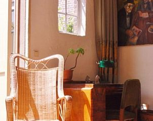 Knusse leeshoek bij Kunsthof de Heuf, een bed and breakfast in Buren, Gelderland, met veel natuurlijk licht en rustgevende sfeer.