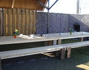 Grote houten picknicktafel op het terras van De Bonenkamp vakantiehuis in Echteld, Gelderland.