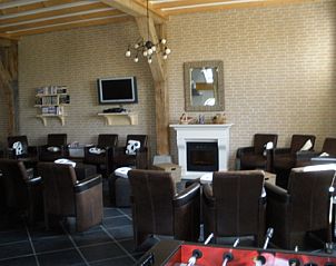 Gezellige woonkamer in De Bonenkamp vakantiehuis in Echteld met comfortabele stoelen en haard in Gelderland.
