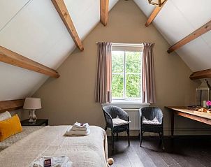 Ruime slaapkamer in Vakantiehuis in Deil, Rivierengebied met uitzicht op de groene omgeving.