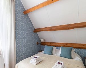 Slaapkamer met blauwe accenten in Vakantiehuis in Deil, Gelderland, biedt een serene sfeer.