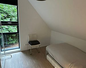 Knusse slaapkamer in Vakantiehuis in Eefde, met uitzicht op de groene omgeving van de Achterhoek.