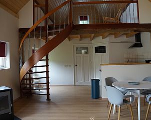 Binnenruimte van Vakantiehuis Het Hof in Lichtenvoorde met stijlvolle wenteltrap en eethoek.