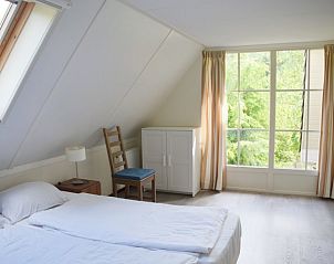 Lichte slaapkamer met uitzicht op de natuur in Het Veluwse Vijverhuis, vakantiehuis in Beekbergen, Veluwe, Gelderland.