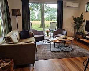 Gezellige woonkamer in chalet In de bosrand Wood 386 Bospark Ede, Ede, Veluwe, met uitzicht op de natuur.