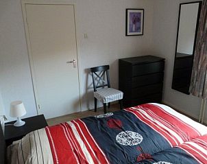 Gezellige slaapkamer in Helfterkamp vakantiehuis, Vaassen, Veluwe, met kleurrijk dekbed.