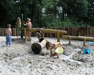 Kinderen spelen in zand bij Helfterkamp vakantiehuis, Vaassen, Veluwe, Gelderland.