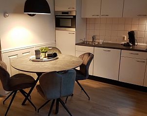 Gezellige eetruimte in Bospark De Schaapskooi bungalow in Epe, Veluwe, met moderne keuken en eettafel.