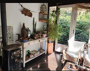 Gezellige binnenruimte van vakantiehuis Jutta in Nunspeet, Veluwe, met rustieke inrichting en uitzicht op groene natuur.