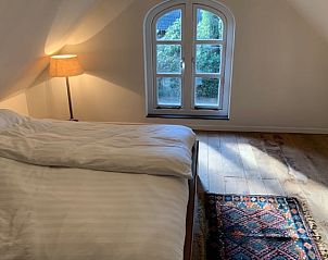 Rustieke slaapkamer met uitzicht in Huisje in Hattem, vakantiehuis op de Veluwe, Gelderland.