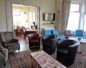 Gezellige woonkamer in De Olde Stoeve vakantiehuis, Nieuwolda, Groningen met comfortabele stoelen.