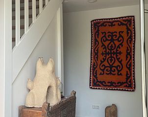 Ingang van Vakantiehuisje in Houwerzijl, Noordwest Groningen met trap en wandtapijt.