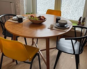 Eettafel in Vakantiehuisje in Houwerzijl, Noordwest Groningen met kleurrijke stoelen.