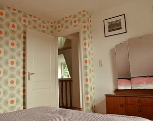 Attractive bedroom in Holiday Home in Melick, Limburg with retro wallpaper and wooden furniture.
