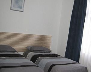 Comfortabele slaapkamer in Huize 'de Hommert' Hoensbroek, Zuid Limburg, vakantiehuis met twee eenpersoonsbedden en natuurlijke lichtinval.