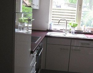 Moderne keuken in Huize 'de hommert' Hoensbroek, vakantiehuis in Zuid Limburg met uitzicht op groene omgeving.
