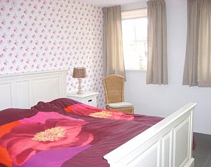 Sfeervolle slaapkamer met bloemenmotief in B&B bij Kaat, Liessel, De Peel, perfect voor een ontspannen verblijf.