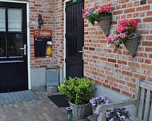 Ingang van B&B bij Kaat, Liessel, De Peel, met kleurrijke bloemen en een uitnodigende uitstraling.