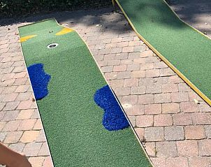 Minigolfbaan in de tuin van Koetshuis & Bakhuis vakantiehuis Hoogeloon, perfect voor familieplezier.