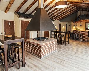 Gezellige binnenruimte van De Schaapskooi vakantiehuis in Hoogeloon met houten balken en open haard, Kempen, Noord Brabant.