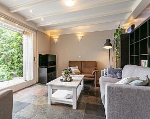 Gezellige woonkamer in Verzicht vakantiehuis, Heeswijk-Dinther, met comfortabele banken en tuinzicht.