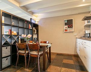 Eetruimte in Verzicht vakantiehuis in Heeswijk-Dinther, met houten tafel en moderne keuken.