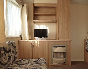 Gezellige woonkamer in Chalet / vakantiehuis in Wilbertoord, Noordoost Brabant, met comfortabele zithoek en televisie.