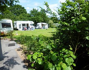 Chalet vakantiehuis in Wilbertoord, Noordoost Brabant, omringd door groene natuur en caravans, ideaal voor een ontspannen verblijf.