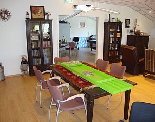 Gezellige binnenruimte in De Lindenhoeve vakantiehuis, Nistelrode, Noordoost Brabant, met boekenplanken en speeltafel.